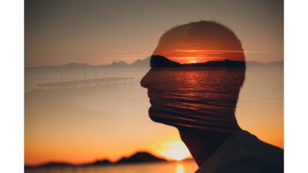 silhoutte of a head and shoulders over a sunset screen so symbolise the calming effects of hypnotherapy for stress
