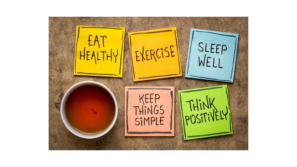 Post it notes with self-care reminders next to a cup of tea